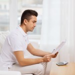 man with papers and calculator at home